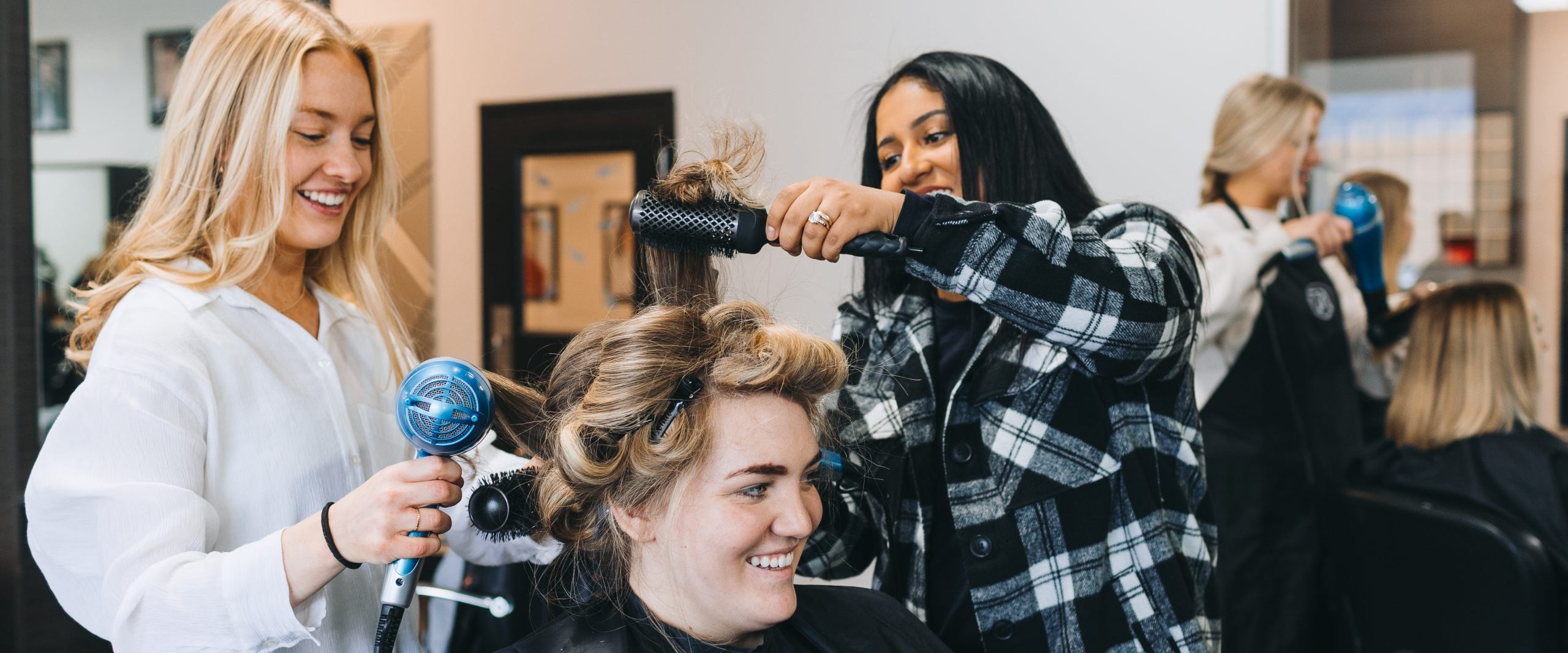 Students curling a woman's hair