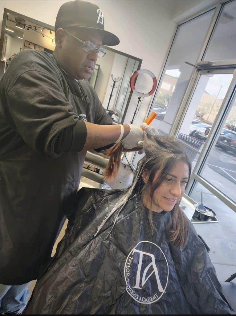 Gavin Oshley applying hair color to a client at Taylor Andrews Academy, in memory via the Gavin Oshley Memorial Scholarship.
